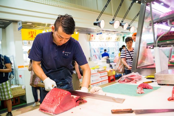A Tsukiji fishmonger slicing a loin of tuna at his counter