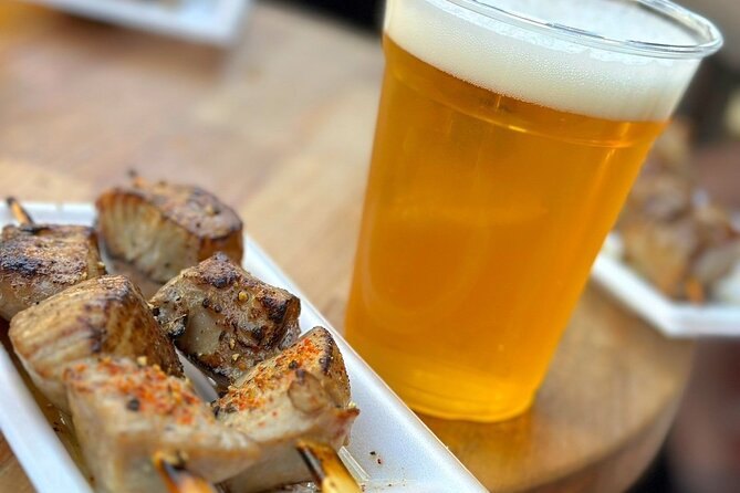A grilled scallop and a glass of beer at a Tsukiji stall counter