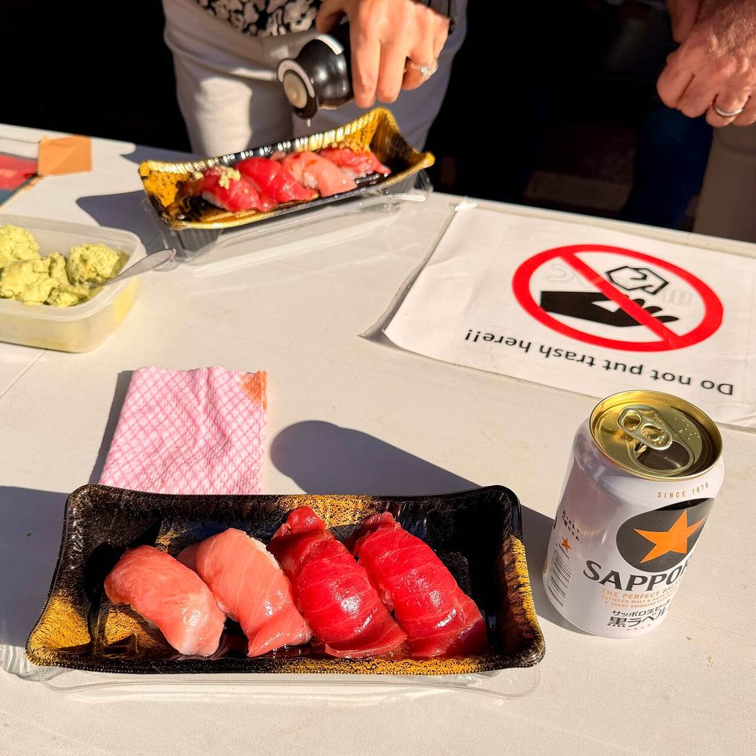 A sushi set and a tray of grilled eel on a Tsukiji market counter