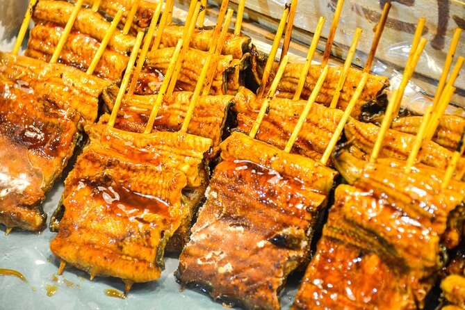 Rows of glazed unagi skewers over the coals at a Tsukiji stall