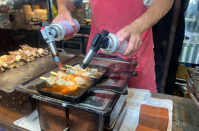 Seafood grilling on a hotplate at a Tsukiji stall, basted as it cooks