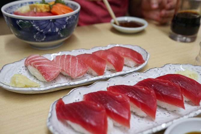 Two plates of tuna sashimi and a rice bowl on a Tsukiji table