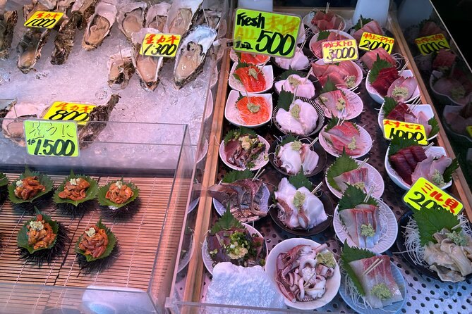 Sea urchin and shellfish laid out at a Tsukiji stall under yellow price tags