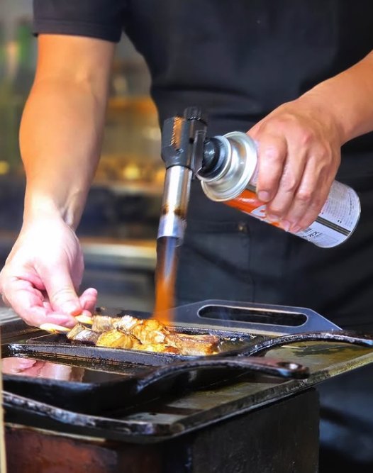 Seafood seared with a torch on a hotplate at a Tsukiji food stall