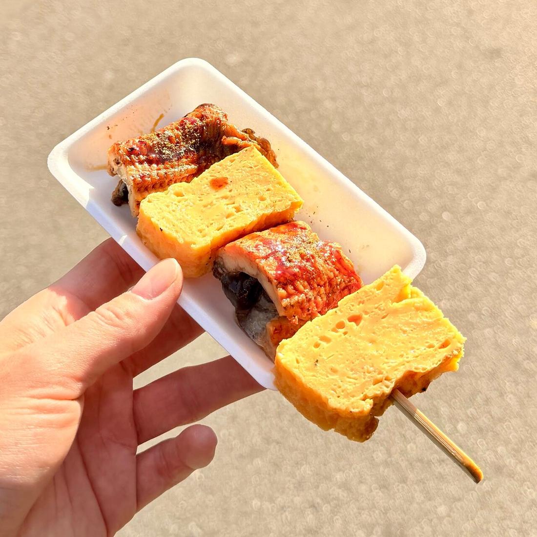 Tamagoyaki on a stick, bought from a Tsukiji stall and eaten where you stand