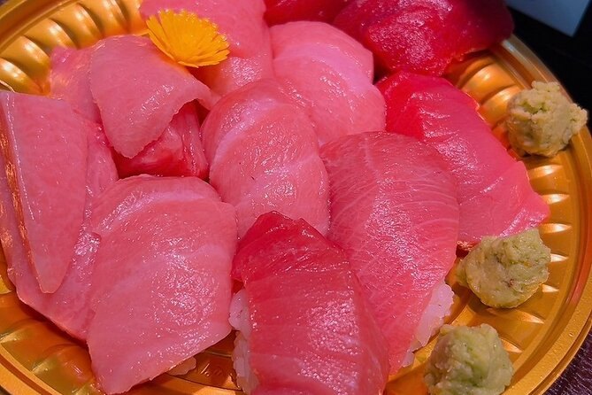 A bowl of thick-cut chutoro sashimi topped with a scallop