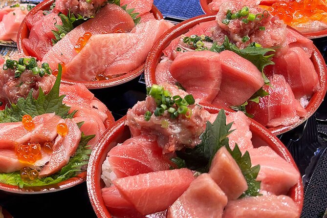 Three bowls of tuna sashimi and salmon roe ready on a Tsukiji counter