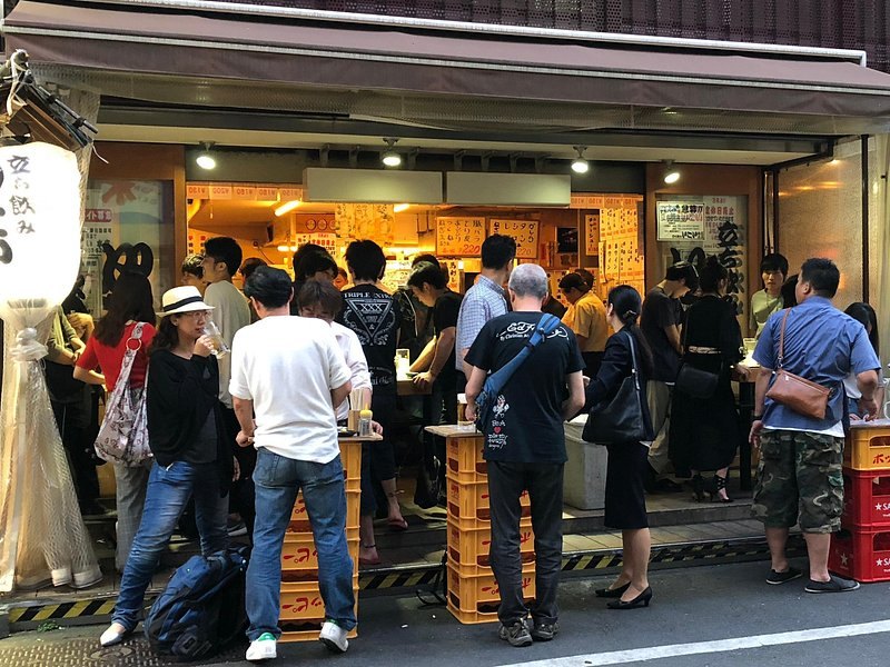Shoppers at the stalls just inside a covered entrance to the Tsukiji Outer Market