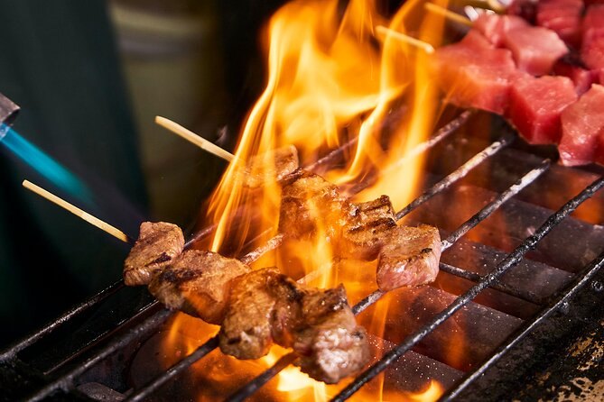 Wagyu beef skewers cooking over an open flame at a Tsukiji stall